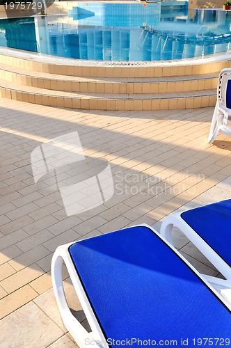 Image of Empty chairs by the pool of  hotel