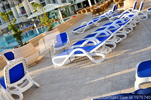 Image of Empty chairs by the pool of  hotel