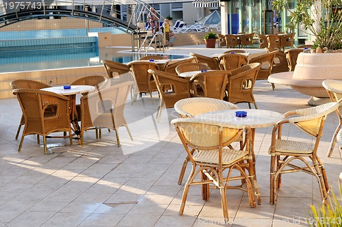 Image of Wooden forniture by the pool of hotel