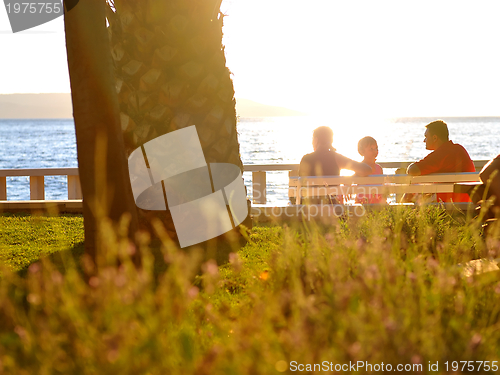 Image of Happy family watching sunset on the beach