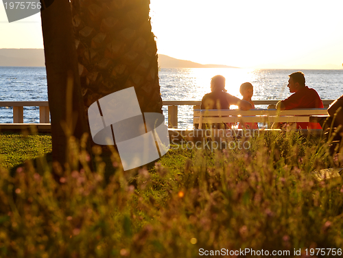 Image of Happy family watching sunset on the beach