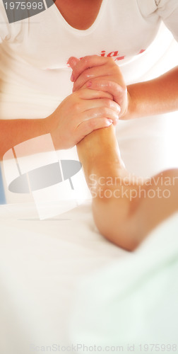 Image of beautiful woman having leg and foot massage at the spa and welln