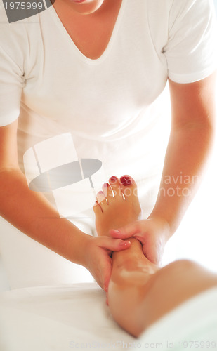 Image of beautiful woman having leg and foot massage at the spa and welln