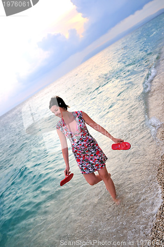 Image of happy and pretty woman alone walking on beach