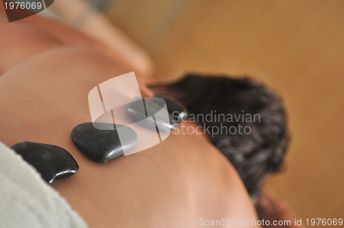 Image of beautiful woman have hotstone massage at spa and wellness center