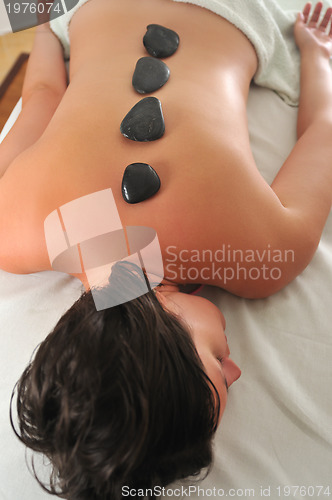 Image of beautiful woman have hotstone massage at spa and wellness center