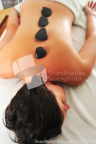 Image of beautiful woman have hotstone massage at spa and wellness center