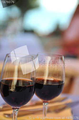 Image of two glasses in outside restaurant with black wine