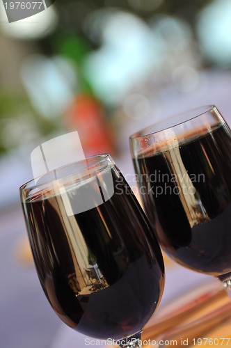 Image of two glasses in outside restaurant with black wine