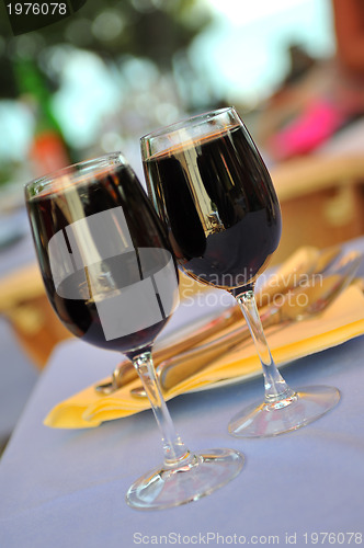 Image of two glasses in outside restaurant with black wine