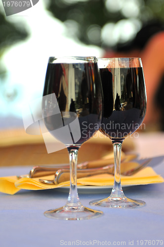 Image of two glasses in outside restaurant with black wine