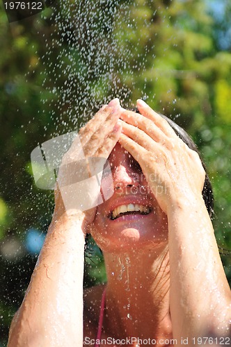 Image of young pretty woman relaxing under shower