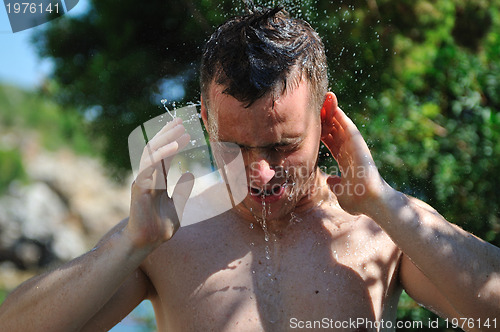 Image of young man relaxing under shower