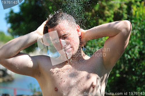 Image of young man relaxing under shower