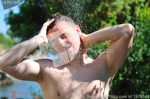 Image of young man relaxing under shower