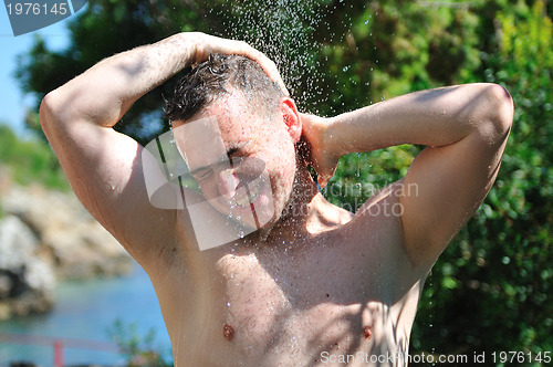 Image of young man relaxing under shower