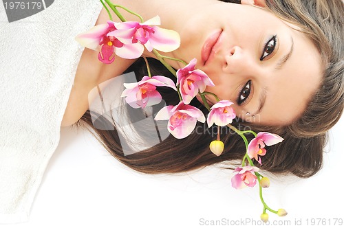 Image of beautiful young  woman face with flower and towel
