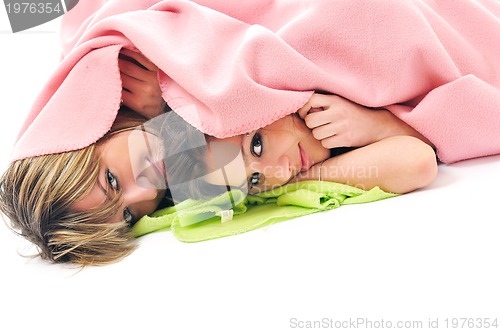 Image of young girls under blanket smile