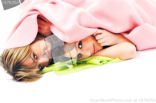 Image of young girls under blanket smile