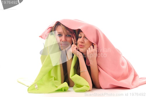 Image of young girls under blanket smile 