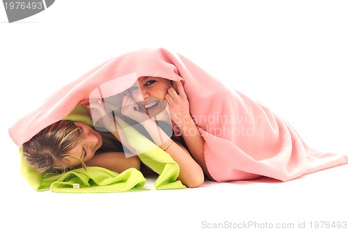 Image of young girls under blanket smile 