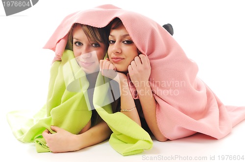 Image of young girls under blanket smile