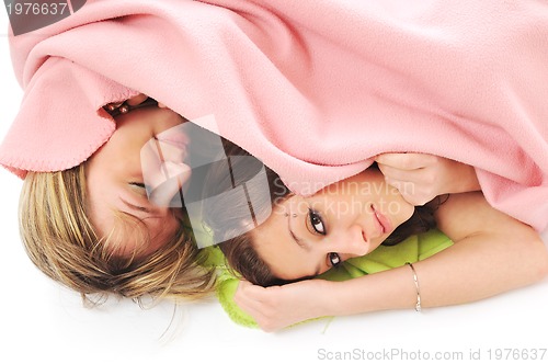 Image of young girls under blanket smile