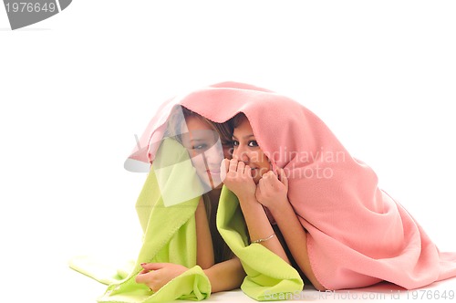 Image of young girls under blanket smile