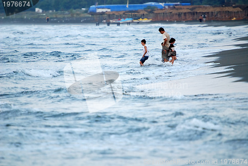 Image of childs having fun on beach at early morning