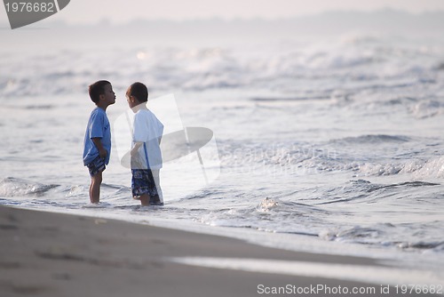 Image of childs having fun on beach at early morning