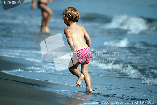 Image of little girl running at the beach
