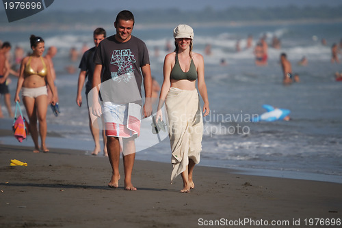 Image of happy couple walking on beach