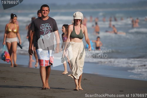 Image of happy couple walking on beach