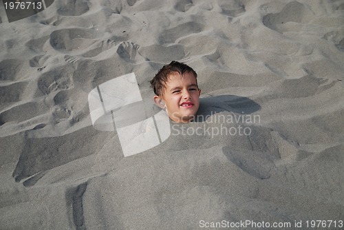 Image of happy children buried in sand