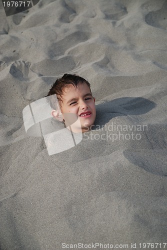 Image of happy children buried in sand