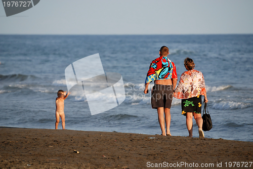 Image of young family relaxing on beach