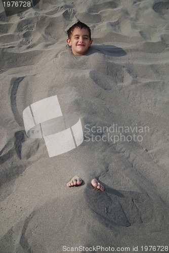 Image of happy children buried in sand