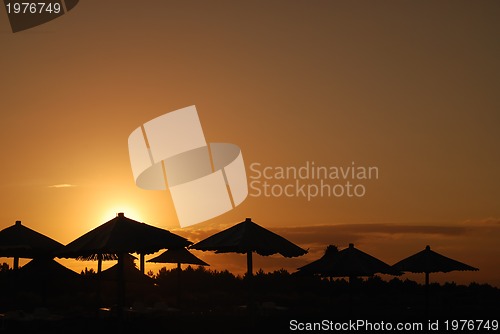 Image of sunshine on beach with beach umbrellas silhouette