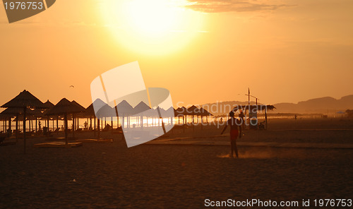 Image of sunshine on beach with beach umbrellas silhouette