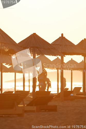 Image of sunshine on beach with beach umbrellas silhouette