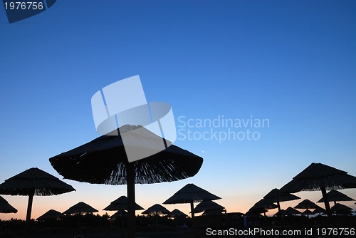 Image of sunshine on beach with beach umbrellas silhouette