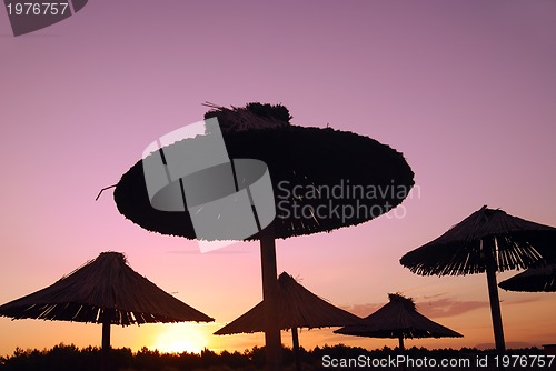Image of sunshine on beach with beach umbrellas silhouette
