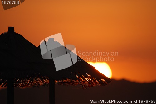 Image of sunshine on beach with beach umbrellas silhouette