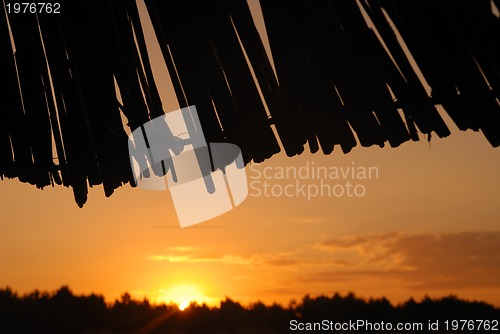 Image of sunshine on beach with beach umbrellas silhouette