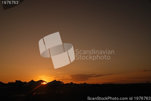 Image of sunshine on beach with beach umbrellas silhouette