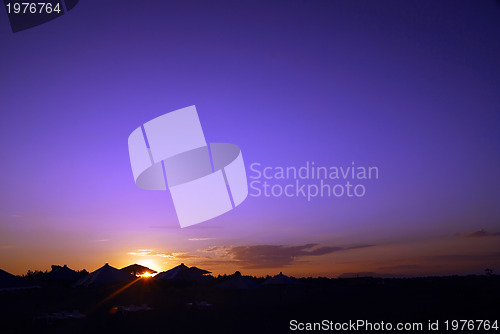 Image of sunshine on beach with beach umbrellas silhouette