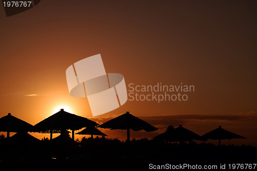 Image of sunshine on beach with beach umbrellas silhouette