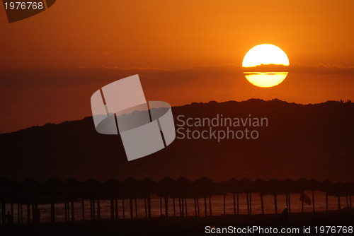 Image of sunshine on beach with beach umbrellas silhouette