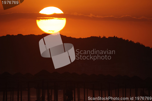 Image of sunshine on beach with beach umbrellas silhouette