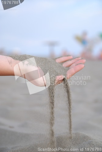 Image of fine sand leaking trought woman hands